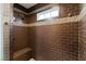 Walk-in shower with dark brown tile and built-in seat at 659 I, Boulder City, NV 89005