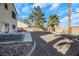 Backyard features a gravel area, patio, hot tub, and mature palm trees at 718 Glenwood Springs Ave, North Las Vegas, NV 89032