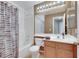 Clean bathroom with shower/tub combo, wood vanity, and updated fixtures at 718 Glenwood Springs Ave, North Las Vegas, NV 89032