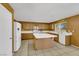 This kitchen includes wood cabinets, white appliances and an island at 718 Glenwood Springs Ave, North Las Vegas, NV 89032