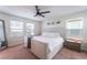 Main bedroom with king bed, ceiling fan, and plenty of natural light at 7563 Chimney Point Ct, Las Vegas, NV 89166