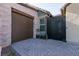 Brown garage door and modern black metal gate with brick paved walkway at 8435 Great Outdoors St, Las Vegas, NV 89166