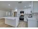 Updated kitchen with white shaker cabinets, quartz countertops, and stainless steel appliances at 8712 Majestic Pine Ave, Las Vegas, NV 89143