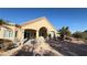 Tan house with covered patio, stone pillars, and desert landscaping at 8821 Sandspring Dr, Las Vegas, NV 89134