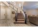 Elegant staircase with a dark wood railing leading to the second floor at 8853 Sherborne Gate Ave, Las Vegas, NV 89148