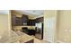 Modern kitchen with dark wood cabinets and granite countertops at 9490 Alma Ridge Ave, Las Vegas, NV 89178