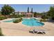 Community pool with lounge chairs and surrounding landscaping at 9490 Alma Ridge Ave, Las Vegas, NV 89178