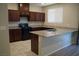 Modern kitchen with granite countertops, dark wood cabinets, and stainless steel appliances at 1023 Desert Dome Ave, North Las Vegas, NV 89086