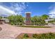 Attractive community entrance with brick pathway, landscaping, and a welcoming sign at 10546 Hartford Hills Ave, Las Vegas, NV 89166