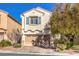 Two-story house with beige exterior, gray shutters, and a two-car garage at 10546 Hartford Hills Ave, Las Vegas, NV 89166