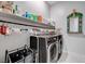 Laundry room with washer, dryer, and storage shelves at 11870 Star Grass Ave, Las Vegas, NV 89138