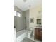 Modern bathroom with gray tile, white bathtub, and a dark wood vanity at 1409 Denver St, Boulder City, NV 89005