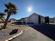 Single story home with palm trees and a rock garden at 1761 Augusta St, Pahrump, NV 89048