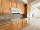 Bright kitchen with wood cabinets, granite counters, and stainless steel appliances at 1761 Augusta St, Pahrump, NV 89048