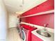 Bright laundry room with red cabinets and utility sink at 1761 Augusta St, Pahrump, NV 89048