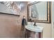 Updated powder room features a pedestal sink and decorative mirror at 2108 Royal Antilles Ct, North Las Vegas, NV 89031