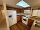 Kitchen with wood cabinets, white appliances, and wood flooring at 2235 High Dunes Ln, Laughlin, NV 89029