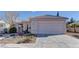 Single story home with a two car garage and desert landscaping at 2693 Hollowvale Ln, Henderson, NV 89052