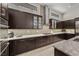 Modern kitchen with dark wood cabinetry, granite countertops, and stainless steel appliances at 39 Cranberry Cove Ct, Las Vegas, NV 89135