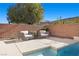 Relaxing poolside seating area with brick wall backdrop at 39 Cranberry Cove Ct, Las Vegas, NV 89135