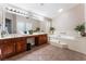 Elegant bathroom boasts double sinks, a soaking tub, and wood cabinets at 5522 Oakview Falls Ct, Las Vegas, NV 89148