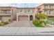 Two-story house with tan exterior, arched garage door, and landscaped front yard at 6034 Pirates Delight Ave, Las Vegas, NV 89139