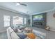 Living room with grey sofas, fireplace, and large TV at 6034 Pirates Delight Ave, Las Vegas, NV 89139