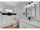 Modern bathroom with white vanity, black tile, and a frameless mirror at 6821 Santa Isabel Ave # 104, Las Vegas, NV 89146