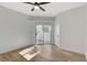 Spacious bedroom featuring wood-look floors, a ceiling fan, and sliding glass door to patio at 6821 Santa Isabel Ave # 104, Las Vegas, NV 89146