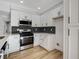 Modern kitchen with white cabinets, herringbone backsplash, and quartz countertops at 6821 Santa Isabel Ave # 104, Las Vegas, NV 89146