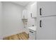 Bright laundry room with white cabinets and wood-look flooring at 6821 Santa Isabel Ave # 104, Las Vegas, NV 89146