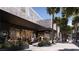 Outdoor seating area of a coffee shop with plants and palm trees at 700 W Carson Ave # 2007, Las Vegas, NV 89106