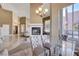 Elegant dining room with a glass table, chandelier, and pool views at 7500 Orange Haze Way, Las Vegas, NV 89149