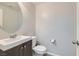 Clean and simple bathroom with single vanity, toilet, and round mirror at 8272 Southern Cross Ave, Las Vegas, NV 89131