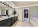 Bathroom with double vanity, large walk-in closet, and bathtub at 9154 Cazador St, Las Vegas, NV 89123