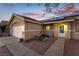 Tan house exterior with white garage door and solar panels at 1066 Bootspur Dr, Henderson, NV 89012