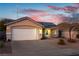 Tan house exterior with white garage door and solar panels at 1066 Bootspur Dr, Henderson, NV 89012