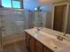 Bathroom featuring double sink vanity and tiled shower with glass door enclosure at 1142 Grass Pond Pl # 3, Henderson, NV 89002