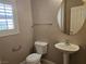 Half bathroom features a pedestal sink, toilet, and a window with plantation shutters at 1142 Grass Pond Pl # 3, Henderson, NV 89002