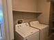 Bright laundry room with functional washer and dryer, plus open shelf for storage at 1142 Grass Pond Pl # 3, Henderson, NV 89002