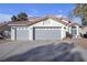 Two-story house with gray double garage doors and landscaping at 1252 Little Sidnee Dr, Las Vegas, NV 89123