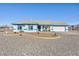 Single-story home with blue accents, landscaped yard, and gravel driveway at 1510 Princeton Cir, Pahrump, NV 89060