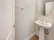 Simple, clean powder room with pedestal sink and round mirror at 170 Rolling Fields Ct, Henderson, NV 89012
