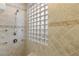 Elegant shower with glass block window and neutral tile at 185 Rocky Star St, Henderson, NV 89012