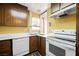 Kitchen with wood cabinets, white appliances, and vinyl flooring at 2462 Paradise Village Way, Las Vegas, NV 89120