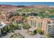 A vibrant aerial view of a residential area, with lush trees and a lake in the background at 30 Strada Di Villaggio # 115, Henderson, NV 89011