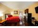 Studio apartment bedroom with a red comforter and hardwood floors at 30 Strada Di Villaggio # 115, Henderson, NV 89011