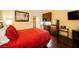 Studio bedroom with red bedding, kitchenette, and hardwood floors at 30 Strada Di Villaggio # 115, Henderson, NV 89011