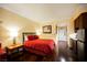 Cozy bedroom with a red comforter and hardwood floors at 30 Strada Di Villaggio # 115, Henderson, NV 89011