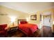 Comfortable bedroom with red bedding and hardwood floors at 30 Strada Di Villaggio # 115, Henderson, NV 89011